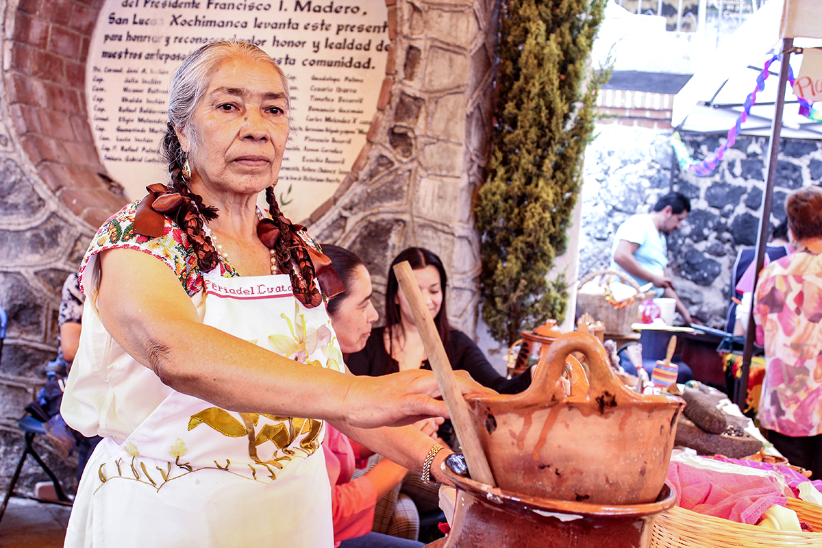 Eleuteria Romero Contreras junto a una olla de sus frijoles cuatatapa durante la Muestra Gastronómica y Cultural Cuatatapa 2017 el 23 de abril en el pueblo de San Lucas Xochimanca.