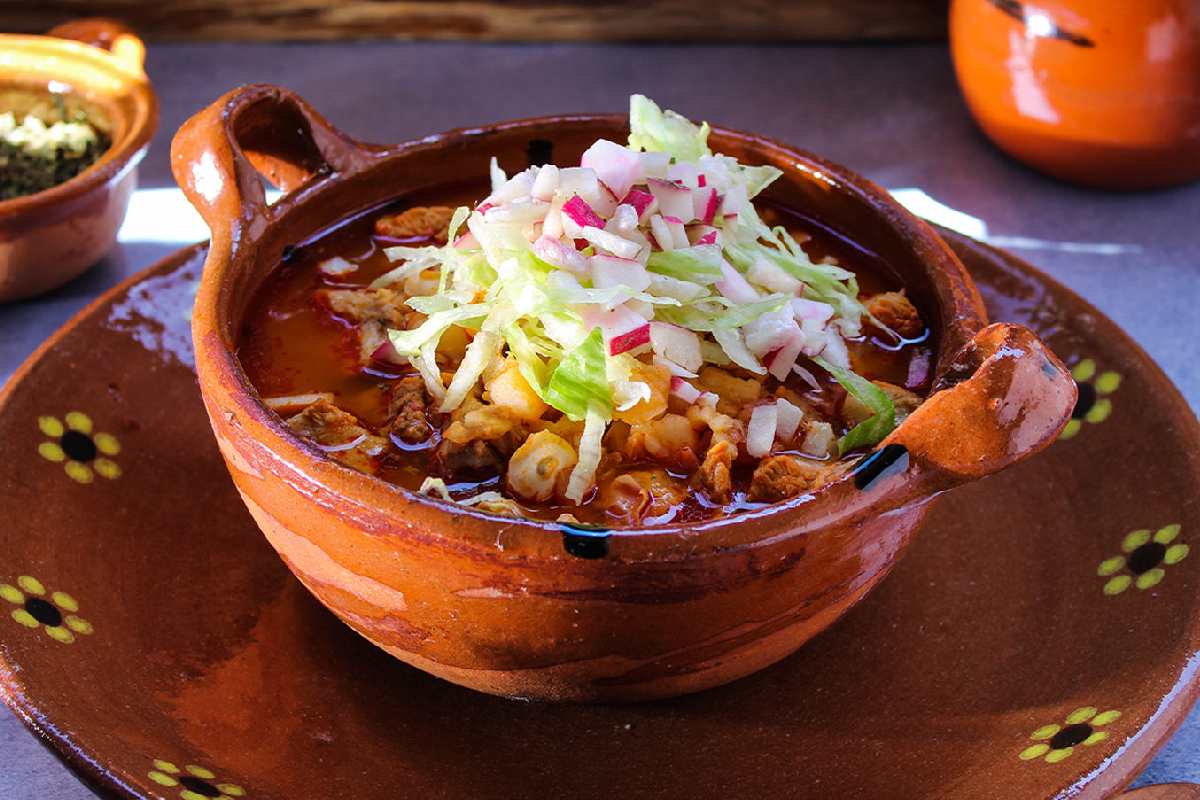 Plato con pozole vegano rojo con setas.